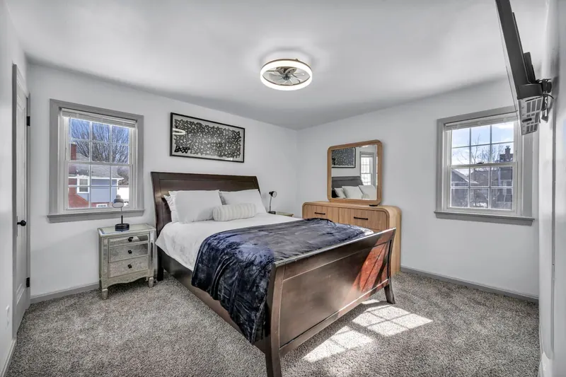 Bedroom with a queen sleigh bed between two windows