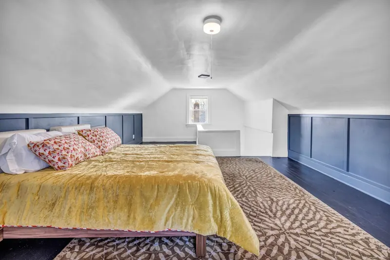 Top floor bedroom under the eaves, with navy panelling along the low wall