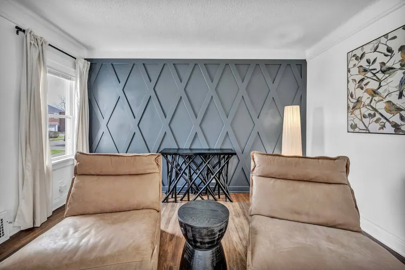 Seating in front of the panelled navy wall, with two leather loungers