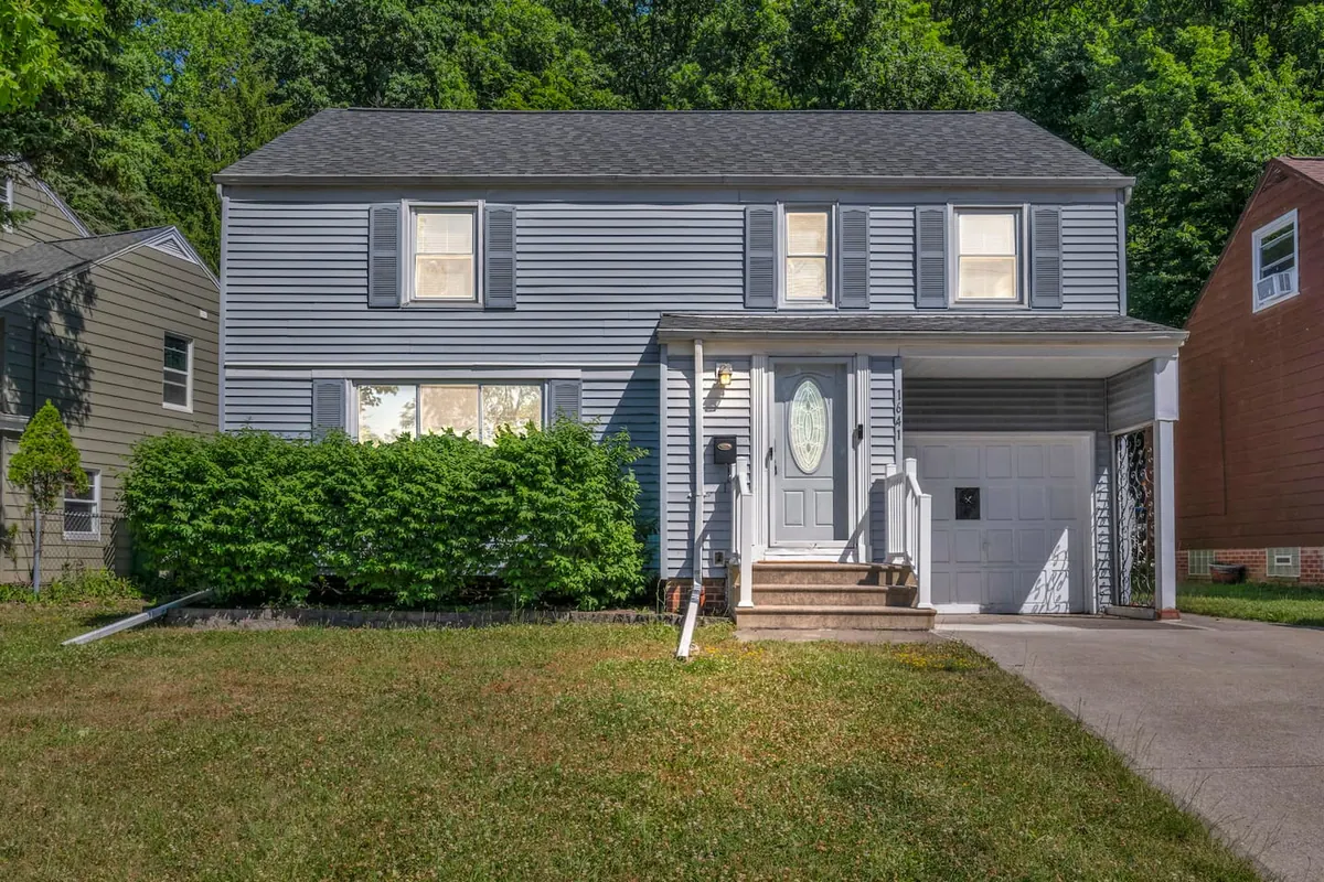 Gray two story house with an attached garage and a lawn out front